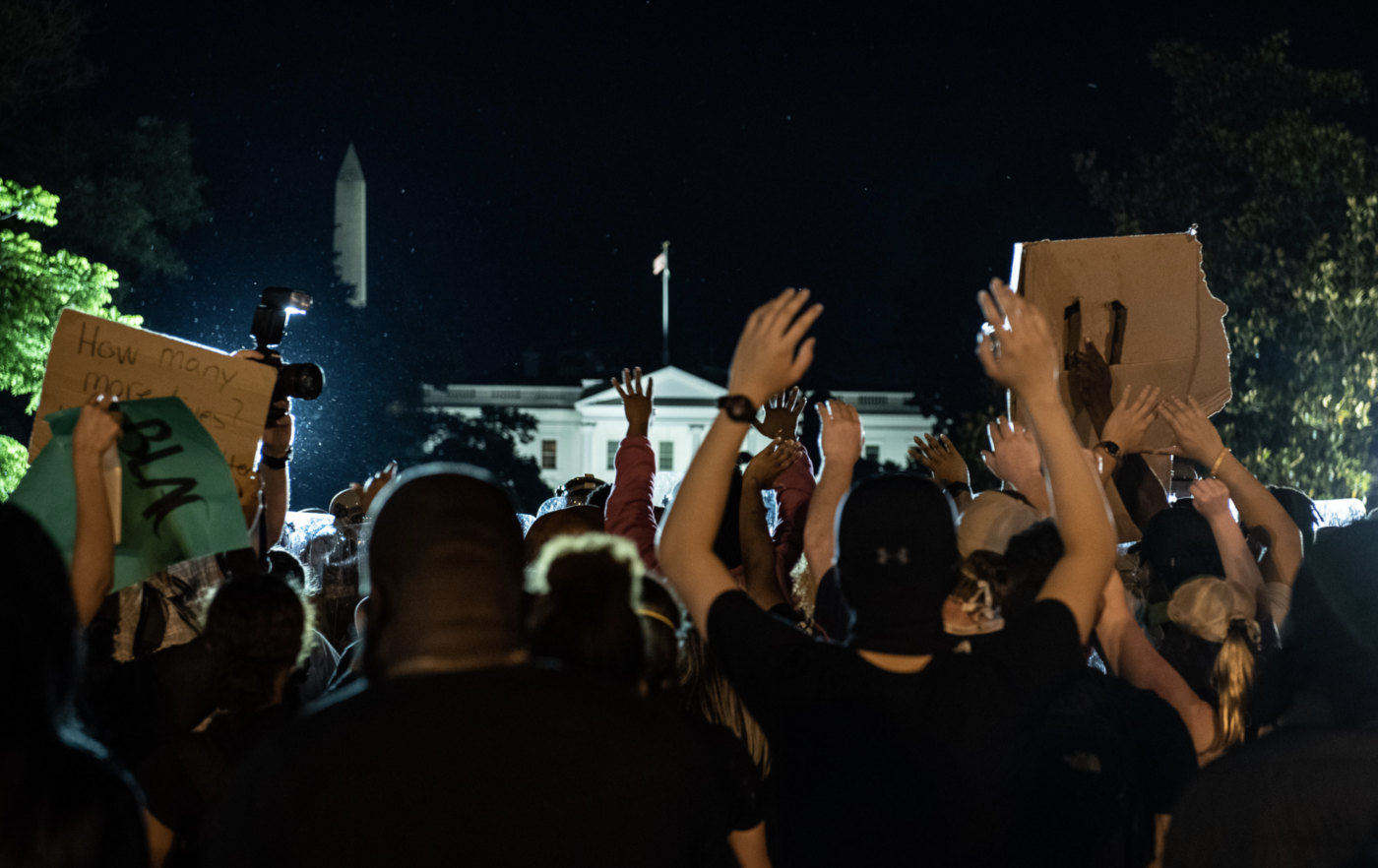 Protesters outside the White House with their hands raised