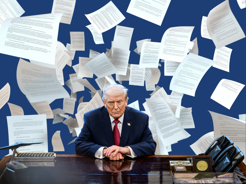 Image of Donald Trump at a desk with sheets of paper flying behind him.