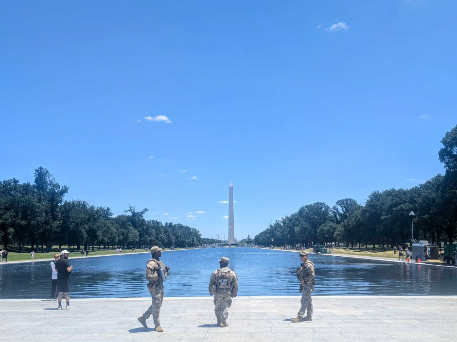 Image of three National Guard troops standing in front of the reflecting pool.