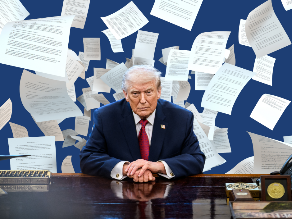 Donald Trump sitting at desk with papers flying around him.