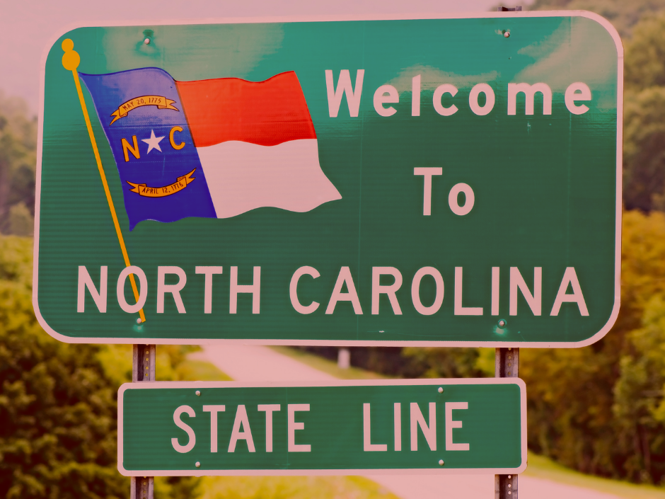 Image of a "Welcome To North Carolina" road sign with a red filter.